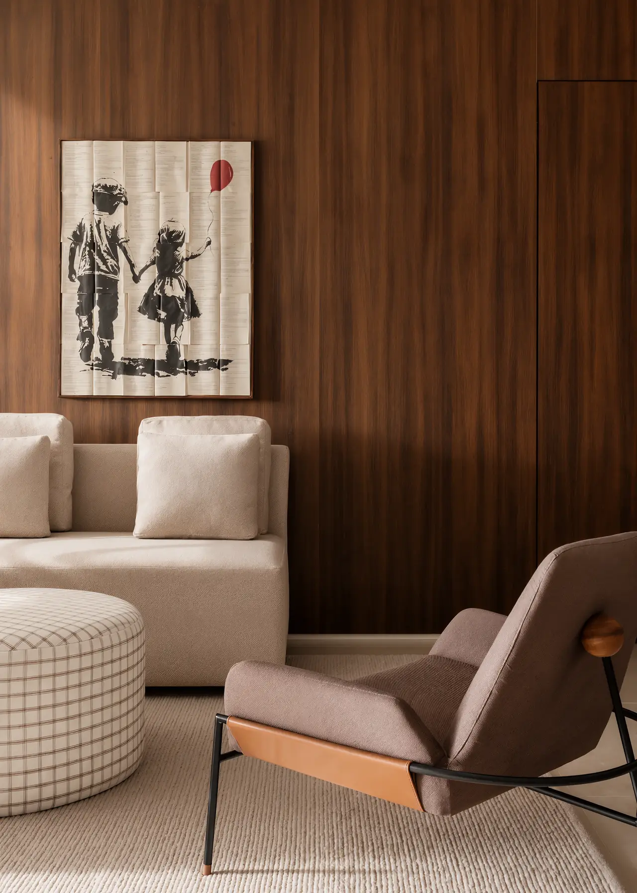 Quadro de duas crianças de mãos dadas com balão vermelho, pintado sobre páginas de livro, em parede de madeira acima de sofá bege